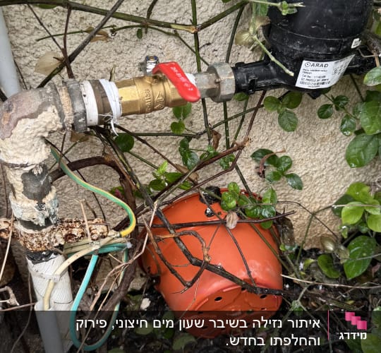 ברז עם ידית אדומה וצינור מתכת חלוד